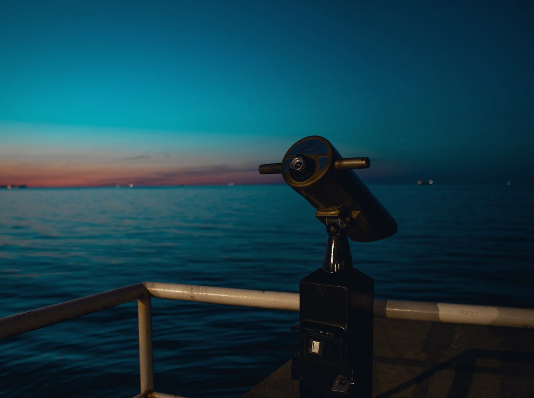 Luneta apontada para o horizonte sobre o mar ao entardecer